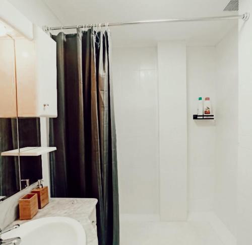 a bathroom with a black shower curtain and a sink at SWEET HOME BILBAO in Bilbao