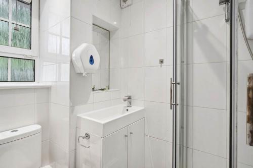 a white bathroom with a shower and a sink at APlaceToStay Central London Apartment, Waterloo (UPT) in London
