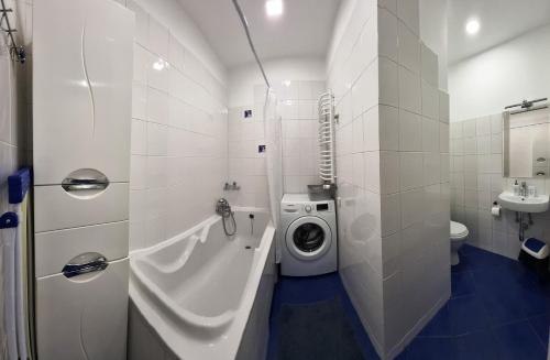 a bathroom with a washing machine next to a toilet at Cozy Apartment in Lviv