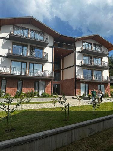 un edificio de apartamentos con gente parada fuera de él en Apart Hotel Falkon, en Bakuriani