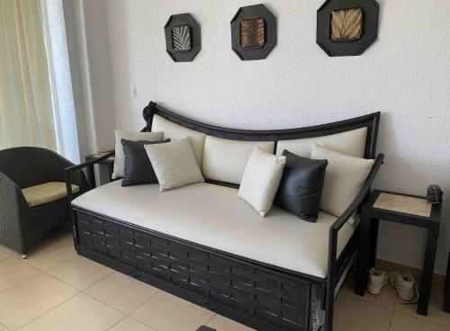 a bed with black and white pillows on it at Twin Towers Acapulco (Caleta) in Acapulco