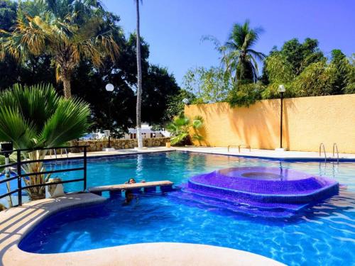 a large swimming pool with blue water in a yard at Twin Towers Acapulco (Caleta) in Acapulco
