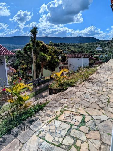 a cobblestone road with a palm tree and buildings at Pouso de Santana in Tiradentes
