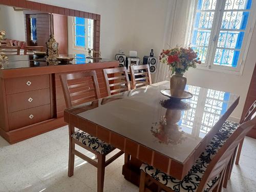 una cucina e una sala da pranzo con tavolo e sedie di Villa Doudi a Al Ḩārah al Kabīrah