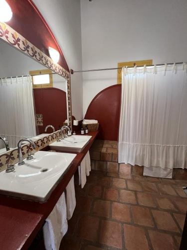 a bathroom with two sinks and a large mirror at La Vaca Tranquila in San Carlos