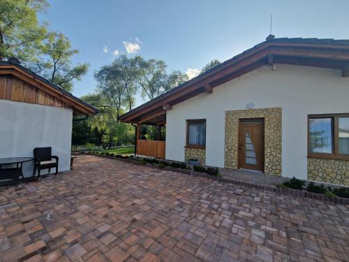 a house with a brick patio in front of it at Villa Garden in Bešeňová