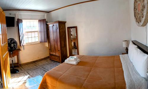 a bedroom with a bed and a window at Pouso de Santana in Tiradentes
