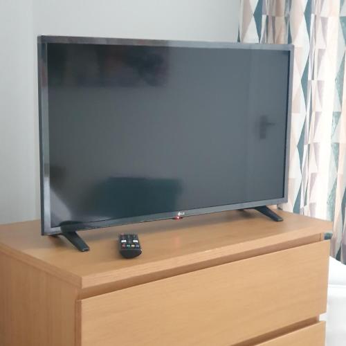 a flat screen tv sitting on top of a dresser at Canterbury Delight in Canterbury