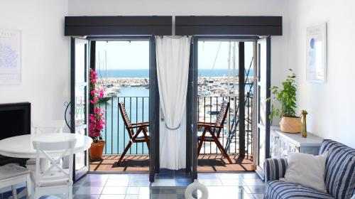 een woonkamer met een balkon met uitzicht op de oceaan bij First line in Puerto Banus (Primera linea) in Marbella