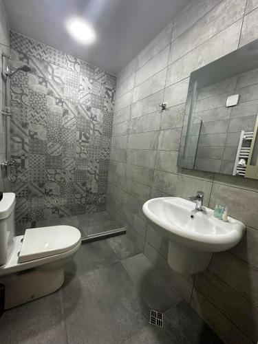 un baño con lavabo e inodoro en Apart Hotel Falkon, en Bakuriani