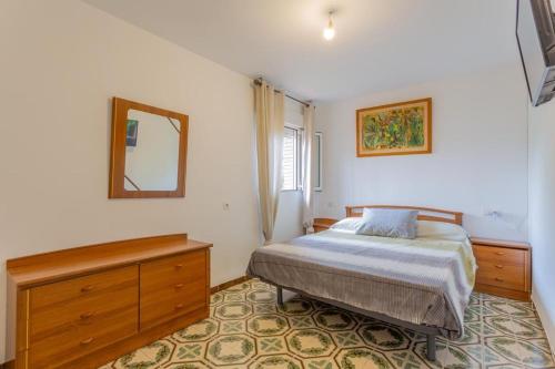 Un dormitorio con una cama y un espejo en la pared. en Bungalow el puntal Padul, en El Padul