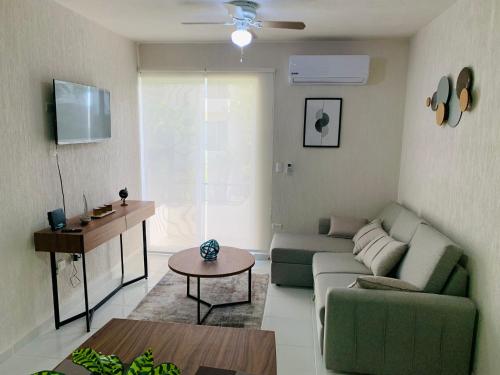 a living room with a green couch and a table at Espacioso Depto. - next to zamna TULUM in Tulum