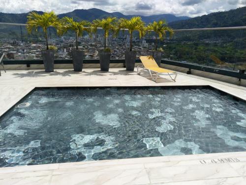 a swimming pool on the roof of a building with palm trees at Edificio M-30 in Ibagué