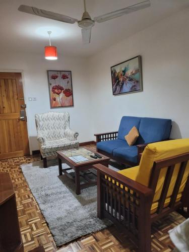 a living room with a blue couch and a table at MOONLIGHT HOMES EAST CHURCH ROAD Westlands in Nairobi