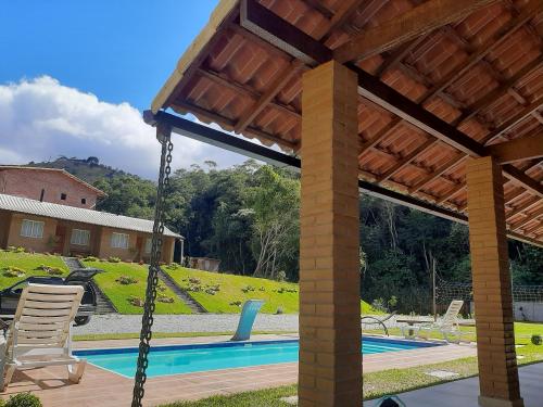um baloiço em frente a uma piscina em Chalés Bem-me-quer Itaipava em Itaipava