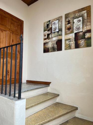 a staircase with two paintings on the wall and a door at Casa Stella Centro Histórico in Guatemala