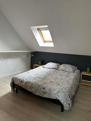 une chambre avec un lit et une lucarne dans l'établissement Superbe maison 4 personnes avec Vidéo-projecteur, à Amiens