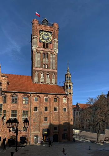 a large brick building with a clock tower at Apartamenty Sowa Toruń in Toruń