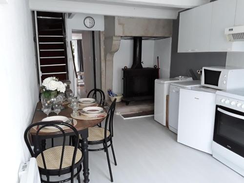 a kitchen with a table with chairs and a stove at L'Atout Charme in Bains-les-Bains