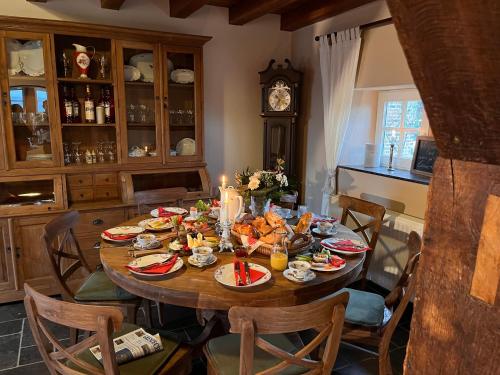 a table with food and a clock in a kitchen at La belle Maison in Sippenaeken