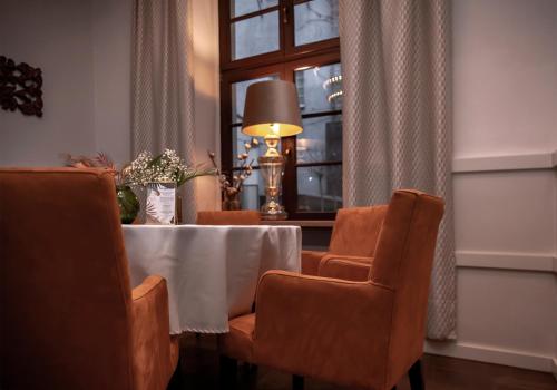 a dining room with a table and chairs and a window at Apartamenty Sowa Toruń in Toruń