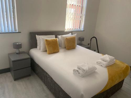 a bedroom with a large bed with towels on it at Nottingham City Centre Short Stay Apartments with Parking in Nottingham