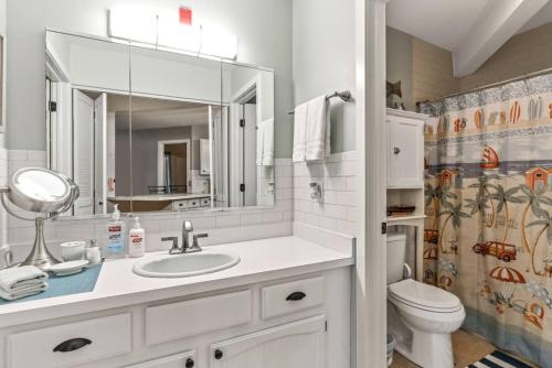 een badkamer met een wastafel, een toilet en een spiegel bij Lake Geneva's resort amenities in Lake Geneva