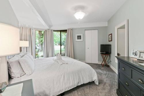 a bedroom with a white bed and a television at Lake Geneva's resort amenities in Lake Geneva