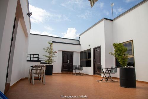 a patio with chairs and tables on a white building at Executive Two Bedroom Apartment in Accra in Accra