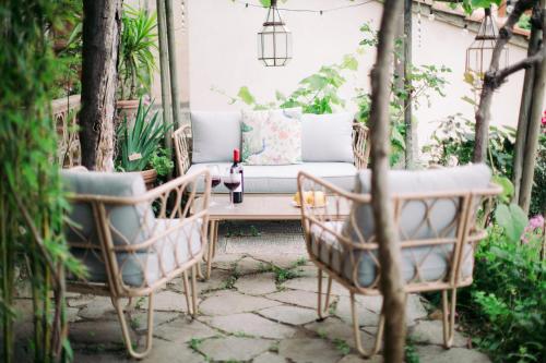 un patio con mesa, sillas y sofá en La Casa nel Borgo, en Bibbona