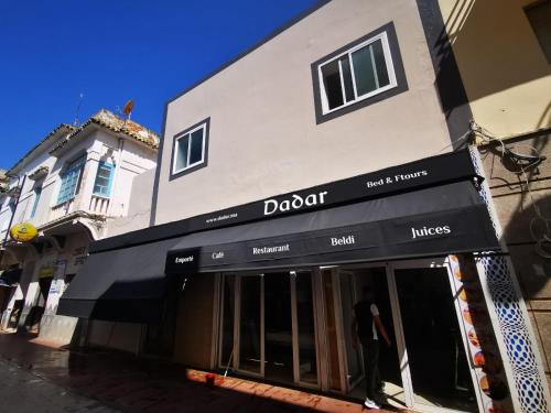 a store with a black awning in front of a building at Dadar in Larache