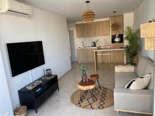 a living room with a flat screen tv and a couch at Appartement Calpe ApoloV Ibiza Style in Calpe