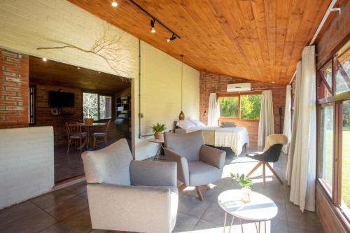 a patio with chairs and a table and a dining room at Cabana no Campo Caminho do Salto Ventoso in Farroupilha