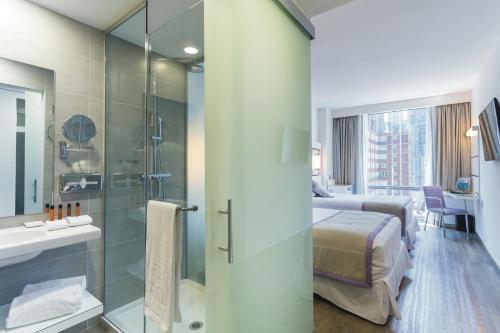 a bathroom with a shower and a bed and a sink at Riu Plaza New York Times Square in New York