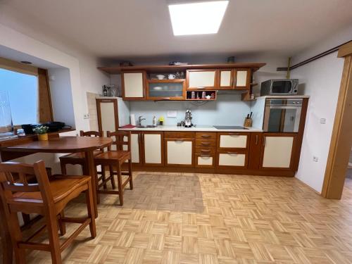 a kitchen with wooden cabinets and a table and chairs at Apartment Sawetz - Ptuj in Ptuj