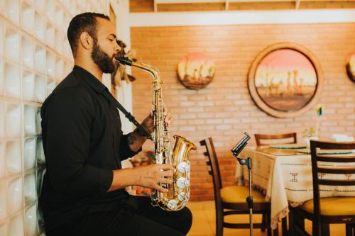 a man playing a saxophone in a restaurant at Pedra do Sino Hotel in Piranhas