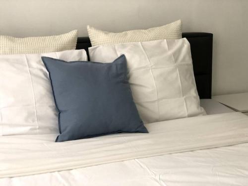 1 cama con almohadas blancas y almohada azul en Private studio in Antwerp en Amberes