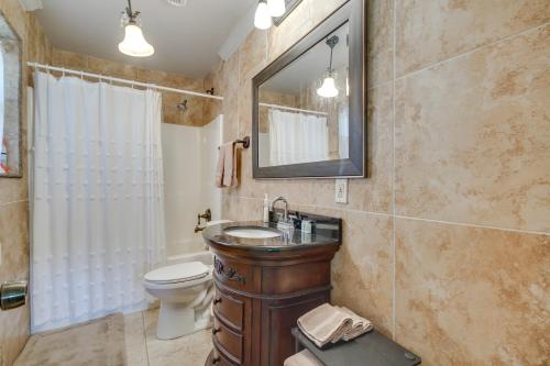 a bathroom with a sink and a toilet and a mirror at Inviting Gulfport Home with Private Pool and Yard in Gulfport