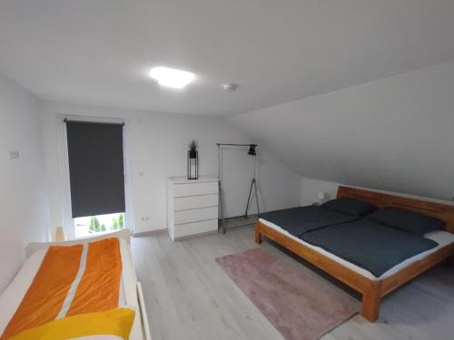 a bedroom with two beds and a white wall at Ferienwohnung Down Under am Bodensee in Uhldingen-Mühlhofen