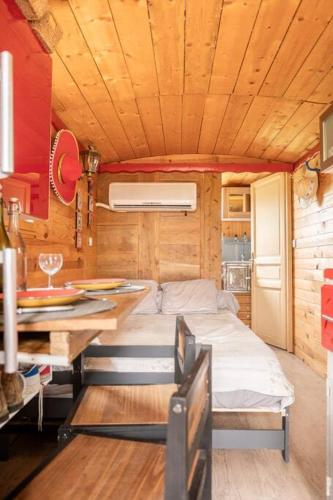 une petite pièce avec un lit et une table dans l'établissement Le Mas de la Mélie, à Arles