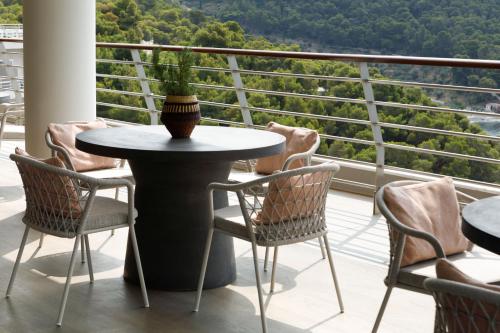 a table and chairs on a balcony with a view at Sirene Blue Luxury Beach Resort in Poros