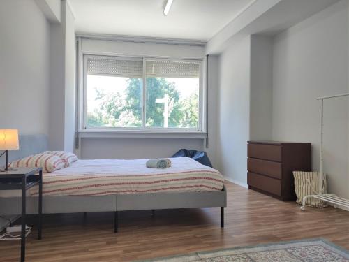 um quarto com uma cama e uma janela em DISCOVER PORTO - Boavista 2 em Porto
