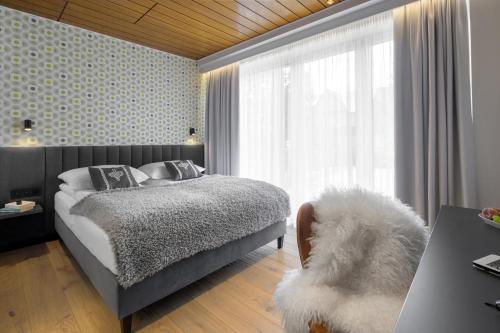 a bedroom with a bed and a large window at Tatry Mozaika Willa PREMIUM & SPA - Sauna, Jacuzzi, Flipper by RentiloPL in Zakopane