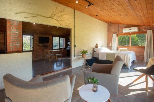 a room with a bed and a living room at Cabana no Campo Caminho do Salto Ventoso in Farroupilha