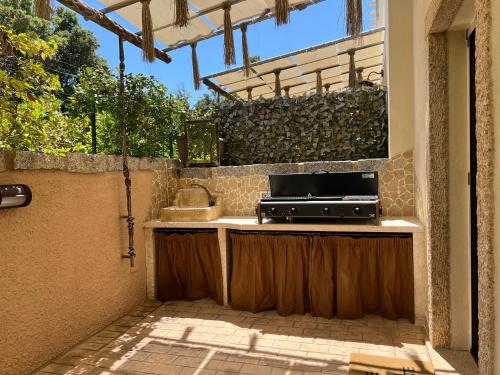a outdoor kitchen with a sink and a stove at Antica Fonte Holiday Homes in San Pantaleo