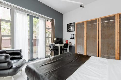 a bedroom with a bed and a chair and a desk at Zocher6 BnB a monumental town house in the city center in Utrecht