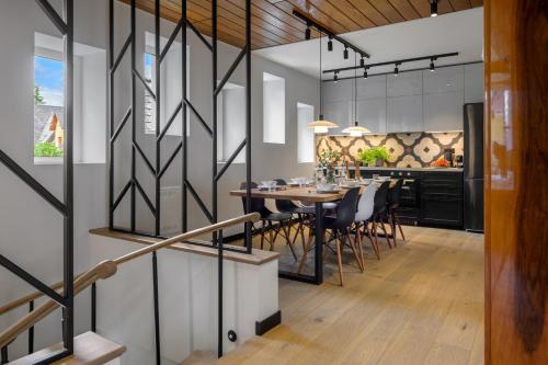 a dining room and kitchen with a table and chairs at Tatry Mozaika Willa PREMIUM & SPA - Sauna, Jacuzzi, Flipper by RentiloPL in Zakopane