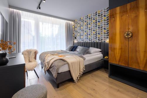 a bedroom with a bed and a window at Tatry Mozaika Willa PREMIUM & SPA - Sauna, Jacuzzi, Flipper by RentiloPL in Zakopane