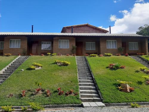 a house with a garden in front of it at Chalés Bem-me-quer Itaipava in Itaipava