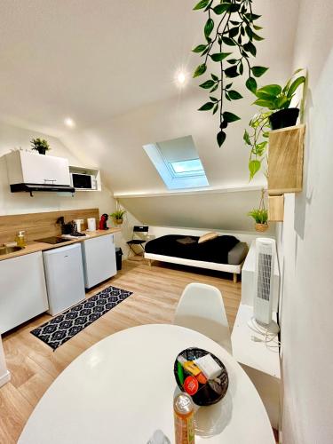 Il comprend un salon avec une table blanche et une cuisine. dans l'établissement Malaka Home Anzin, à Anzin